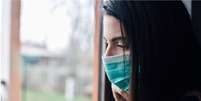 Woman looks through a window  Foto: Getty Images / BBC News Brasil