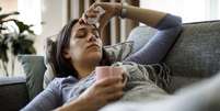 mulher doente deitada no sofá  Foto: Getty Images / BBC News Brasil