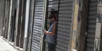 Homem olha o celular ao lado de lojas fechadas no Rio de Janeiro
04/03/2021 REUTERS/Pilar Olivares  Foto: Reuters