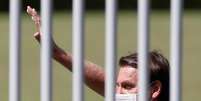 O presidente do Brasil, Jair Bolsonaro, acena ao se encontrar com apoiadores que se manifestam para comemorar seu aniversário no Palácio da Alvorada, em Brasília  Foto: Adriano Machado / Reuters