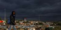 Homem passa por um assentamento informal enquanto restrições à mobilidade são amenizadas no Soweto, África do Sul. 7 de abril de 2021. REUTERS/Siphiwe Sibeko  Foto: Reuters