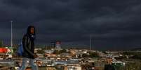 Homem passa por um assentamento informal enquanto restri&ccedil;&otilde;es &agrave; mobilidade s&atilde;o amenizadas no Soweto, &Aacute;frica do Sul. 7 de abril de 2021. REUTERS/Siphiwe Sibeko  Foto: Reuters