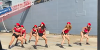 O grupo dan&ccedil;ando twerk em frente ao novo navio de guerra australiano HMAS Supply  Foto: @alexbrucesmith/Twitter / BBC News Brasil