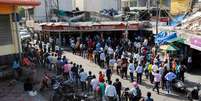 Pessoas fazem fila em frente a loja de bebidas em Nova Délhi depois de governo local decretar seis dias de lockdown para frear disseminação do coronavírus
19/04/2021 REUTERS/Adnan Abidi  Foto: Reuters