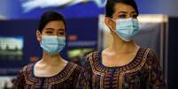 Comissárias de bordo usam máscaras em aeroporto durante pandemia da Covid-19. 21/11/2020. REUTERS/Edgar Su  Foto: Reuters