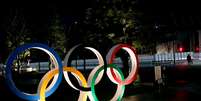 Os anéis olímpicos são iluminados em frente ao Estádio Nacional de Tóquio, no Japão  Foto: Kim Kyung-Hoon / Reuters