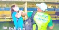 Jornalista teve o celular arrancado à força, foi agredida e ofendida por um homem que vestia boné branco e camisa com mangas azuis.  Foto: Reprodução / Twitter / Estadão
