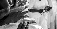 Homem toca atabaque em ritual de umbanda   Foto: istock