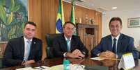 Flávio e Jair Bolsonaro em encontro com o presidente do Patriota, Adilson Barroso  Foto: Reprodução / Twitter Flávio Bolsonaro / Estadão Conteúdo