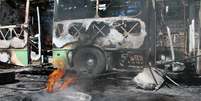 Funcionários de empresa de ônibus, trabalham para remover dois ônibus dos 14 que foram queimados por facções em ataques  Foto: Edmar Barros / Futura Press