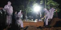 Coveiros com trajes de proteção fazem o sepultamento noturno no cemitério de Vila Formosa, em São Paulo
25/03/2021
REUTERS/Amanda Perobelli  Foto: Reuters