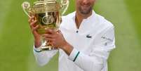 Novak Djokovic posa para foto ao lado do trof&eacute;u de Wimbledon ap&oacute;s conquistar o Grand Slam brit&acirc;nico em Londres
11/07/2021 REUTERS/Toby Melville  Foto: Reuters