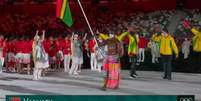 Remador Riilio Rii foi o porta-bandeira para a delegação de Vanuatu e ganhou fama na internet por 'rivalizar' com o porta-bandeira de Tonga que 'lançou a moda' dos 'besuntados' (Reprodução / SporTV)  Foto: Lance!