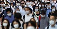 Passageiros usando máscaras de proteção caminham em direção à estação de Shinagawa, em Tóquio
28/07/2021 REUTERS/Kim Kyung-Hoon  Foto: Reuters