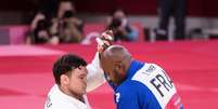 O japonês Aaron Wolf enfrenta o francês Teddy Riner na disputa por equipes do judô em Tóquio  Foto: Enrico Calderoni/Reuters
