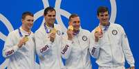 Liderada por Dressel, a equipe dos EUA exibe a medalha de ouro conquistada na prova do revezamento 4x100m medley  Foto: Sergei Bobylev/TASS/Reuters