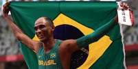 Alison dos Santos exibe a bandeira brasileira ao comemorar sua medalha de bronze  Foto: Hannah Mckay/Reuters