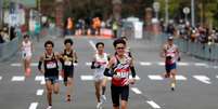 Atletas cruzam a linha de chegada diante de pequenos grupos de espectadores durante meia maratona de Hokkaido-Sapporo, evento-teste para a maratona olímpica da Tóquio 2020
05/05/2021 REUTERS/Issei Kato  Foto: Reuters