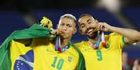 Richarlison comemora ouro olímpico do futebol ao lado de Matheus Cunha  Foto: Reuters