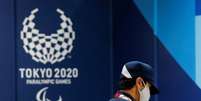 Seguran&ccedil;a usando m&aacute;scara de prote&ccedil;&atilde;o passa em frente o alogo dos Jogos Parl&iacute;mpicos T&oacute;quio 2020 em T&oacute;quio
16/08/2021 REUTERS/Issei Kato  Foto: Reuters