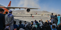 Afegãos foram correndo para o aeroporto de Cabul na segunda-feira (16/8) na esperança de deixar o país  Foto: AFP / BBC News Brasil