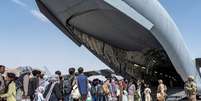Afegãos embarcam para deixar o país no aeroporto Hamid Karzai. 21/8/2021. Air Force/Senior Airman Brennen Lege/Handout via REUTERS   Foto: Reuters