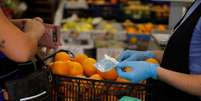 Pessoa paga por suas compras em loja de frutas de Ronda, na Espanha, em meio a dissemina&ccedil;&atilde;o da Covid-19
09/10/2020
REUTERS/Jon Nazca  Foto: Reuters