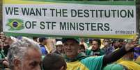 Num cartaz em inglês, manifestante pede a destituição dos ministros do STF no protesto em São Paulo  Foto: AFP / BBC News Brasil