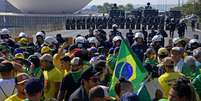 Policiais militares isolam área próxima ao Congresso Nacional para evitar aproximação de manifestantes pró-Bolsonaro  Foto: AFP / BBC News Brasil