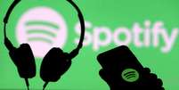 Um smartphone e um fone de ouvido são vistos na frente de uma projeção de tela de um logotipo do Spotify
01/04/2018
REUTERS/Dado Ruvic/  Foto: Reuters