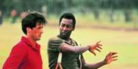 Pelé ensinando Sylvester Stallone a agarrar durante o filme 'Fuga para a vitória' (Reprodução)  Foto: Lance!