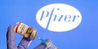 Mulher segura frasco rotulado como de vacina contra Covid-19 em frente ao logo da Pfizer em foto de ilustração
30/10/2020 REUTERS/Dado Ruvic  Foto: Reuters