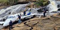 Trabalho de remoção dos itens pessoais dos ocupantes da aeronave que caiu e matou a cantora Marília Mendonça e outras quatro pessoas  Foto: Fred Magno/O Tempo / Estadão