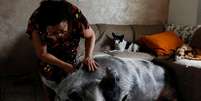 Rosângela dos Santos Lara acaricia sua porca, Lilica, em sua casa em Peruíbe, litoral de São Paulo  Foto: Amanda Perobelli / Reuters