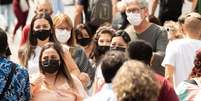 Pedestres são vistos usando máscaras de proteção na Avenida Paulista, na região central de São Paulo  Foto: Daniel Teixeira / Estadão