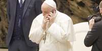 Papa Francisco atende o celular nesta quarta-feira no final da audiência geral no Salão Nervi, no Vaticano  Foto: Massimo Valicchia/NurPhoto / Reuters