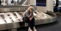 Passageira no aeroporto americano de LaGuardia, em 24 de dezembro; necessidade de isolar tripulantes por conta da covid-19 tem forçado cancelamento de voos, principalmente na China e nos EUA  Foto: Getty Images / BBC News Brasil