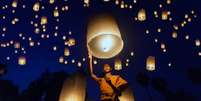 Monge levanta objeto luminoso, em meio a escuro com outros pontos de luz  Foto: Getty Images / BBC News Brasil