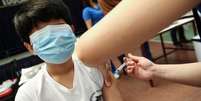 CoronaVac sendo aplicada em criança chilena; vacina foi liberada para uso em público de 6 a 17 anos no Brasil  Foto: Reuters / BBC News Brasil