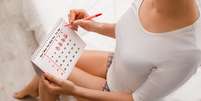 Mulher usando calendário para monitorar ciclo menstrual  Foto: Getty Images / BBC News Brasil