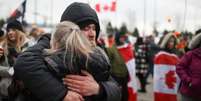 Casal se abra&ccedil;a em meio a protestos no Canad&aacute;  Foto: Reuters / BBC News Brasil