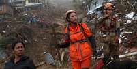 Bombeiros buscam por vítimas em meio a lama que tomou conta de ruas de Petrópolis   Foto: Ricardo Moraes / Reuters