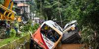  Ônibus é retirado por guindaste do canal da Avenida Washington Luís, em Petrópolis  Foto:  Alexandre Neto/PhotoPress / Estadão