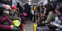 Pessoas carregam malas e outros pertences no metrô de Kiev na manhã de 24 de fevereiro  Foto: AFP / BBC News Brasil