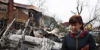 Mulher em frente aos escombros em Kiev, na Ucr&acirc;nia  Foto: Reuters