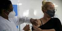 Mulher toma vacina contra covid-19  Foto: REUTERS/Ricardo Moraes