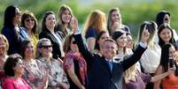 O presidente Jair Bolsonaro faz gestos enquanto participa de cerimônia de hasteamento da bandeira nacional com convidadas em frente ao Palácio da Alvorada, em Brasília  Foto: REUTERS/Ueslei Marcelino