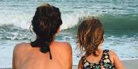 Nas fotos, Mel Fronckowiak aparece de costas na praia com a filha, Nina.  Foto: Instagram/@rodrigosantoro / Estadão