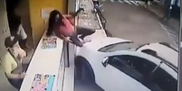 Mulher escapa de atropelamento após conseguir subir em balcão de loja.  Foto: Reprodução / Redes Sociais