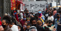 Mulher usando máscara protetora e protetor facial fala ao telefone enquanto pessoas caminham em uma popular rua comercial em meio ao surto de Covid-19 em São Paulo, Brasil, 15 de julho de 2020  Foto: Reuters/Amanda Perobelli / Reuters/Amanda Perobelli